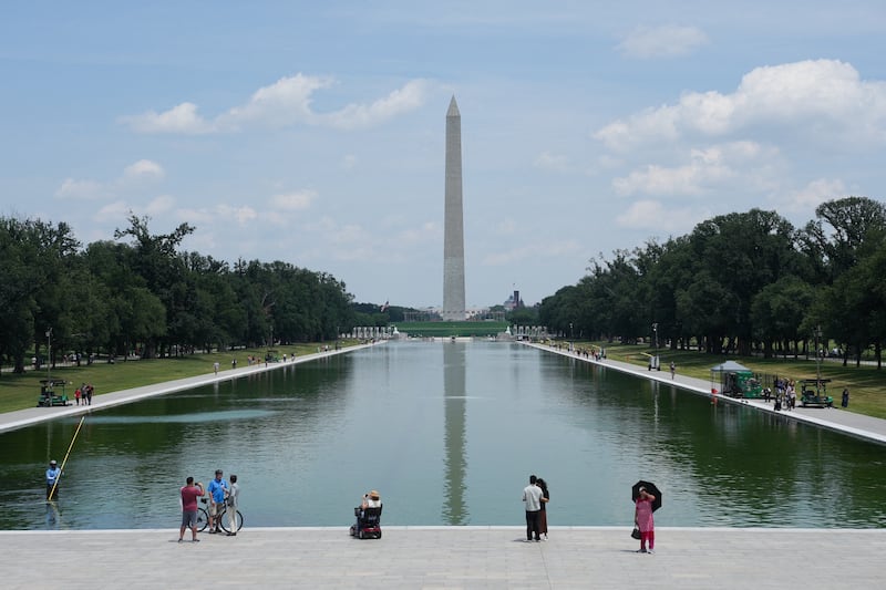 A worker clears algae from the Lincoln Memorial Reflecting Pool, which has been painted blue at the directive of U.S. President Donald Trump, ahead of the 250th anniversary of U.S. Independence, in Washington, D.C., U.S., June 14, 2026.