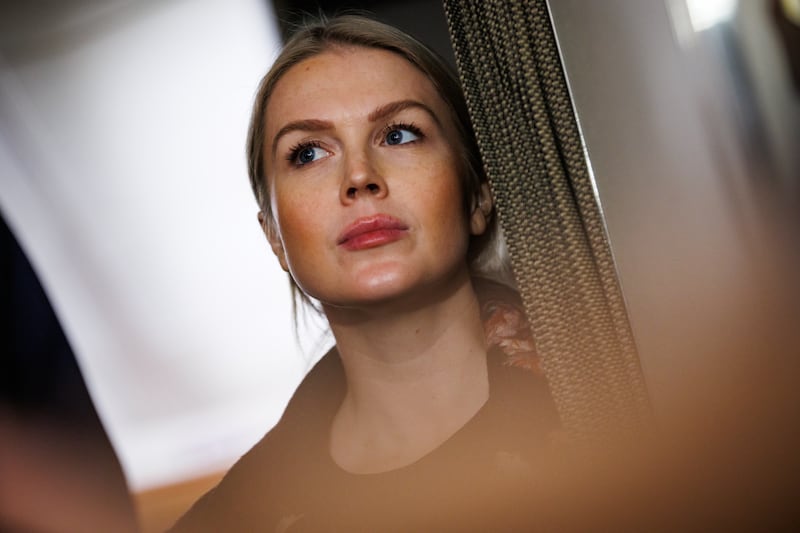 White House Press Secretary Karoline Leavitt listens as U.S. President Donald Trump takes questions from the members of the press aboard Air Force One on January 11, 2026 en route back to the White House from Palm Beach, Florida.