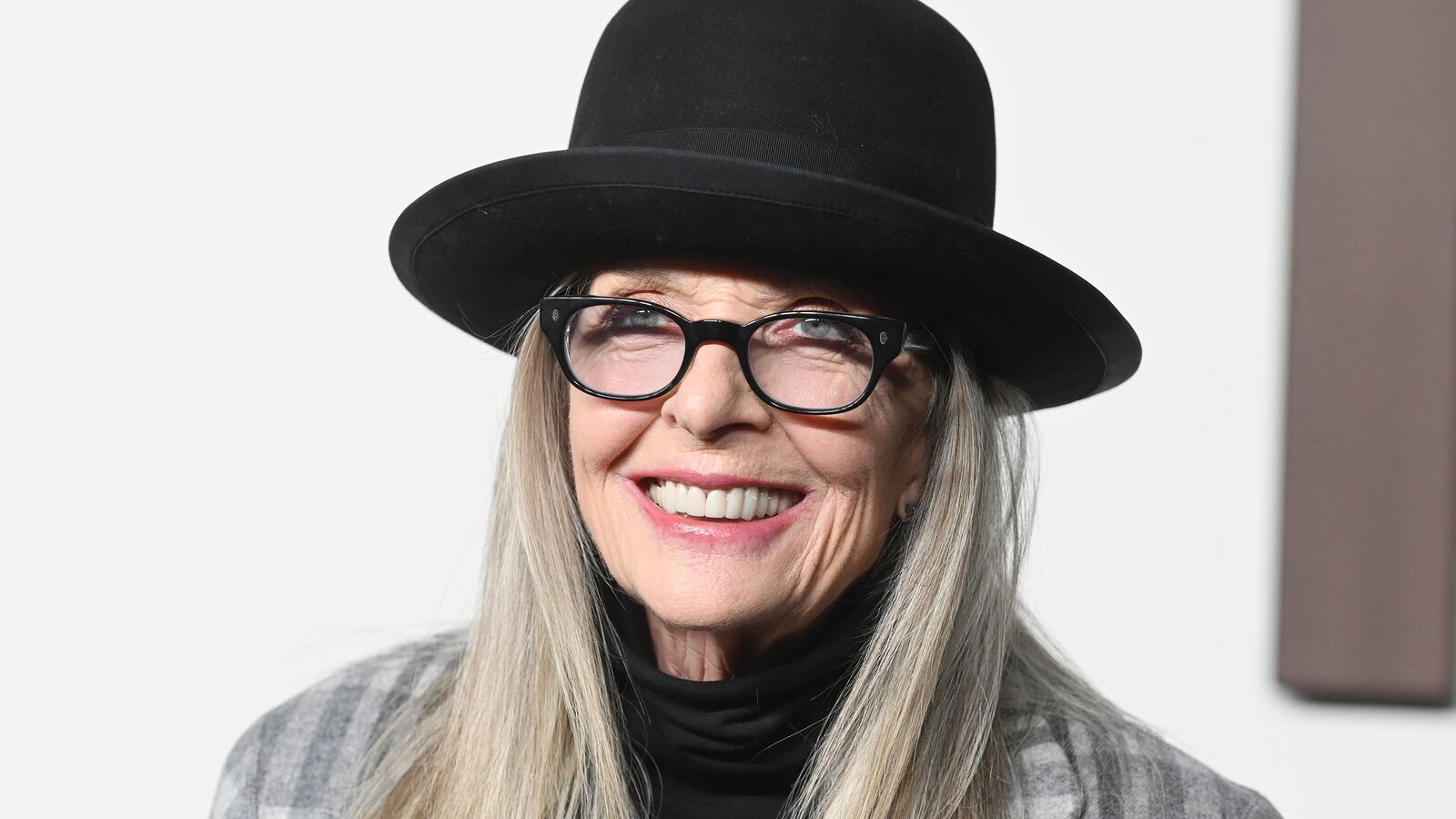 Diane Keaton at the Ralph Lauren Spring 2024 Ready To Wear Fashion Show in 2024, wearing her signature glasses and hat.