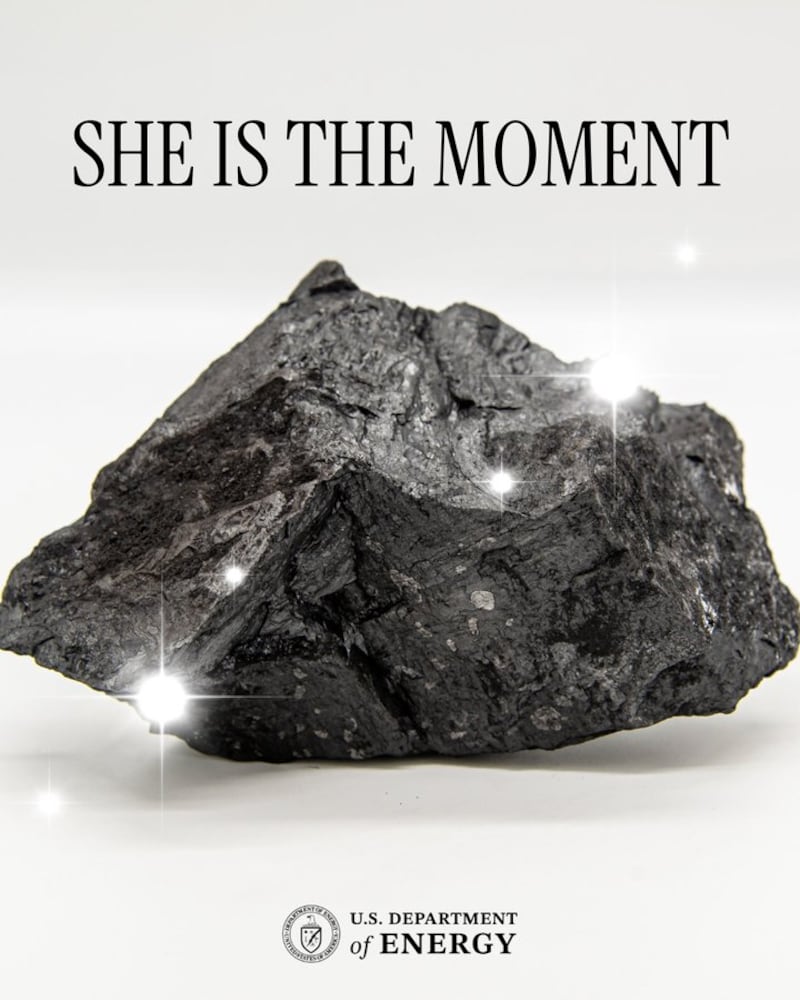 A piece of coal. Text saying "She is the moment" and "U.S. Department of Energy."