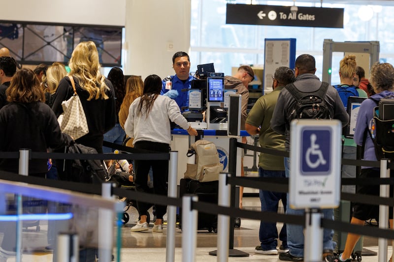 FILE PHOTO: A TSA agent checks travelers at San Diego International Airport during the 2025 government shutdown in San Diego, California, U.S., November 7, 2025. REUTERS/Mike Blake/File Photo