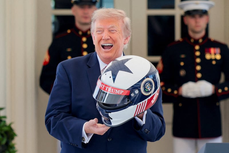 U.S. President Donald Trump reacts after being given a personalised racing helmet during a Freedom 250 Grand Prix Showcase at the White House in Washington, D.C., U.S., July 13, 2026.