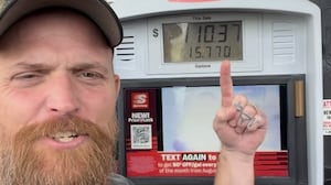 Country rapper Adam Calhoun stands in front of a diesel pump and discusses the high cost of living.
