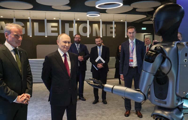 In this pool photograph distributed by the Russian state agency Sputnik, Russia's President Vladimir Putin, accompanied by Sberbank's CEO German Gref, visits an exhibition of the AI Journey international AI (Artificial intelligence) conference in Moscow on November 19, 2025. Russia's anthropomorphic AI-equipped robot developed by technology company Sber was presented to the Russian leader. (Photo by Vyacheslav PROKOFYEV / POOL / AFP) (Photo by VYACHESLAV PROKOFYEV/POOL/AFP via Getty Images)