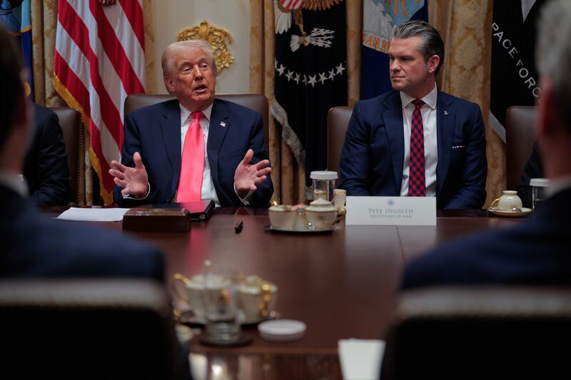 President Donald Trump speaks with Defense Secretary Pete Hegseth seated beside him during a Cabinet meeting on December 02, 2025.