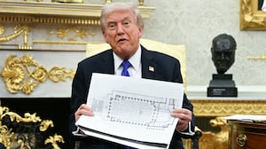 US President Donald Trump shows the floor plan of his planned ballroom.