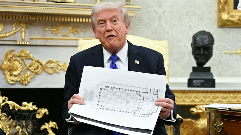 US President Donald Trump shows the floor plan of his planned ballroom.