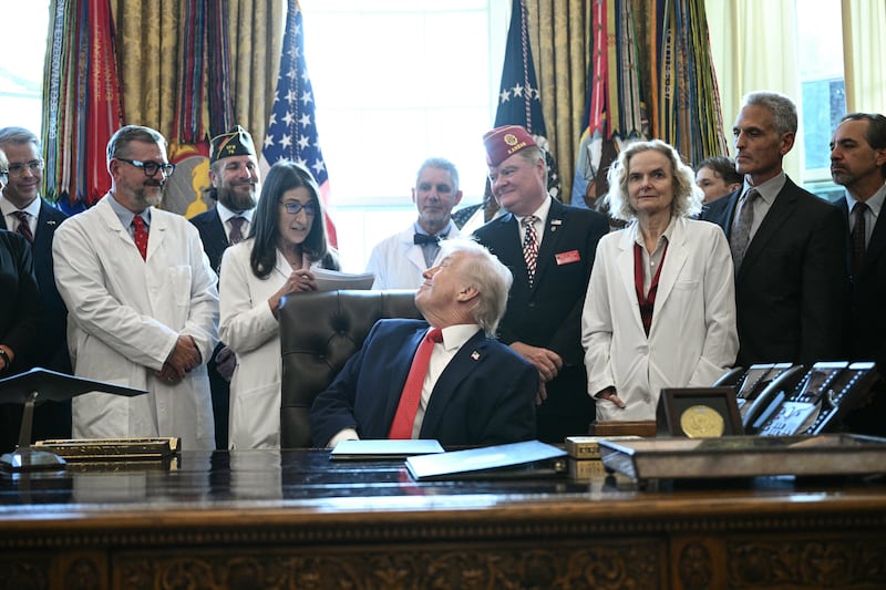 US President Donald Trump listens to Dr. Ilana Braun, Senior Physician and Associate Professor of Psychiatry at Harvard Medical School, before signing an executive order easing restrictions on marijuana in the Oval Office at the White House in Washington, DC, on December 18, 2025. Trump said he was signing an executive order reclassifying marijuana as a less dangerous drug, in one of America's biggest shifts in drug policy for years. The move stops short of full federal legalization for recreational use across the United States but is aimed at encouraging medical research on the use of cannabis products. (Photo by Brendan SMIALOWSKI / AFP via Getty Images)