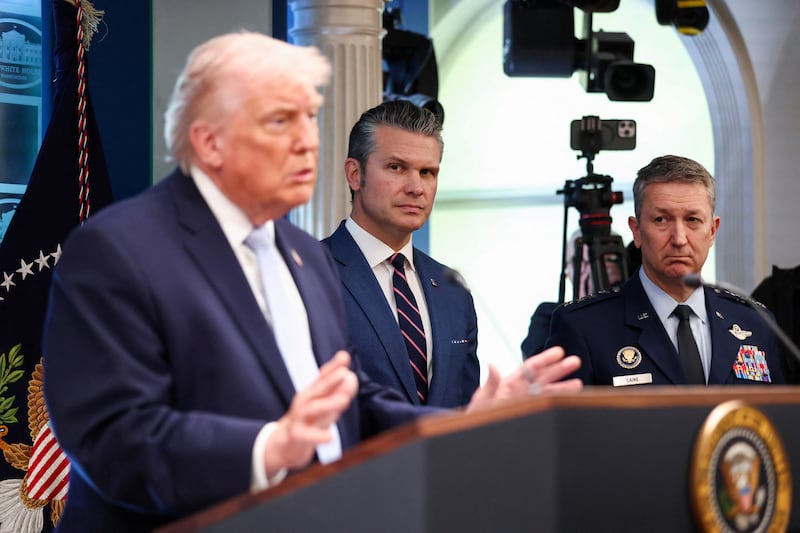 U.S. Secretary of Defense Pete Hegseth and Chairman of the Joint Chiefs of Staff Gen. Dan Caine listen to President Donald Trump speak during a press conference in the James S. Brady Press Briefing Room at the White House in Washington, D.C., U.S., April 6, 2026. REUTERS/Kevin Lamarque