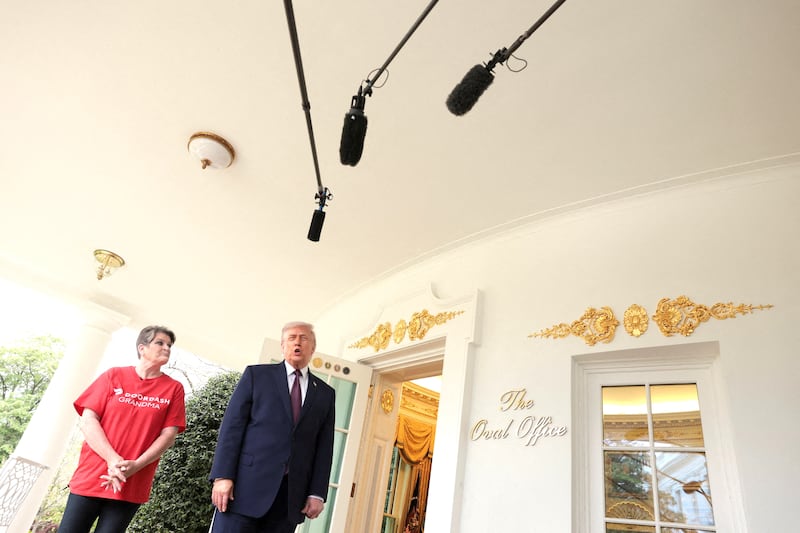 U.S. President Donald Trump speaks with the media next to Sharon Simmons after receiving a McDonald's order via DoorDash.