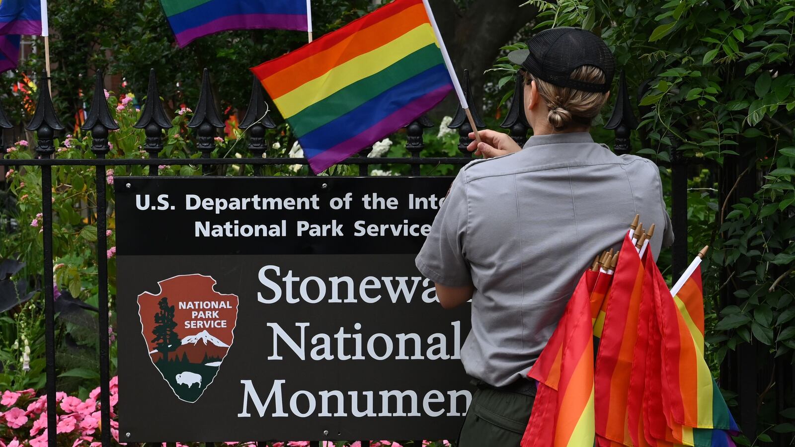 A National Park Service ranger places rainbow flags on the fence at the Stonewall National Monument in the West Village neighborhood of Greenwich Village in Lower Manhattan, New York City on June 19, 2019.