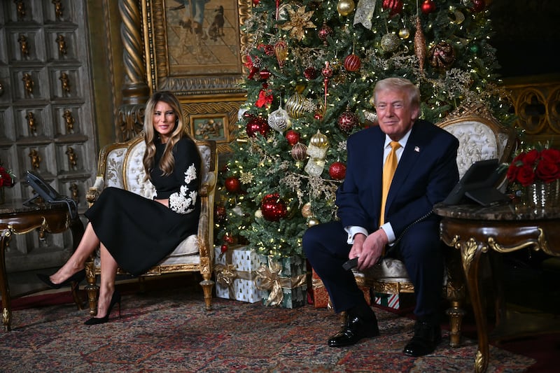 US President Donald Trump and first lady Melania Trump participate in NORAD Santa tracker phone calls, on Christmas Eve, from the Mar-a-lago club in Palm Beach, Florida, on December 24, 2025. (Photo by ANDREW CABALLERO-REYNOLDS / AFP via Getty Images)