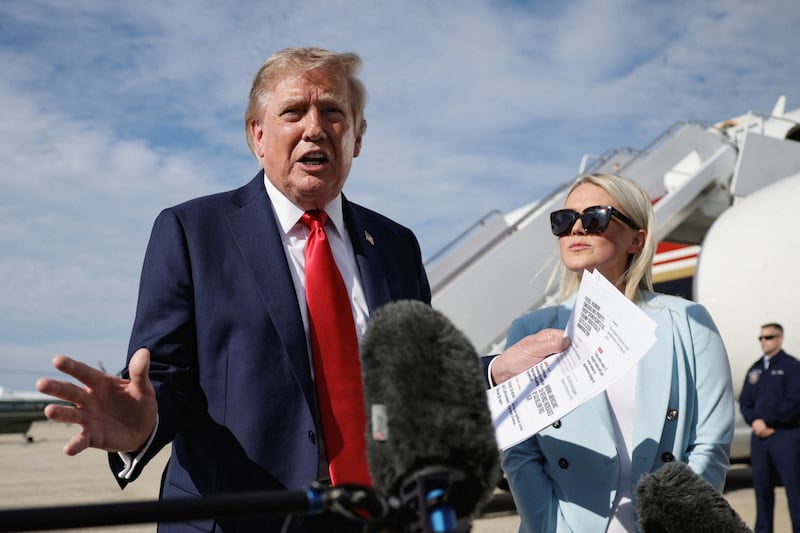 President Donald Trump, next to White House Press Secretary Karoline Leavitt, speaks to the media before boarding Air Force One at Joint Base Andrews in Maryland, en route to Myrtle Beach, South Carolina, on August 21, 2026.