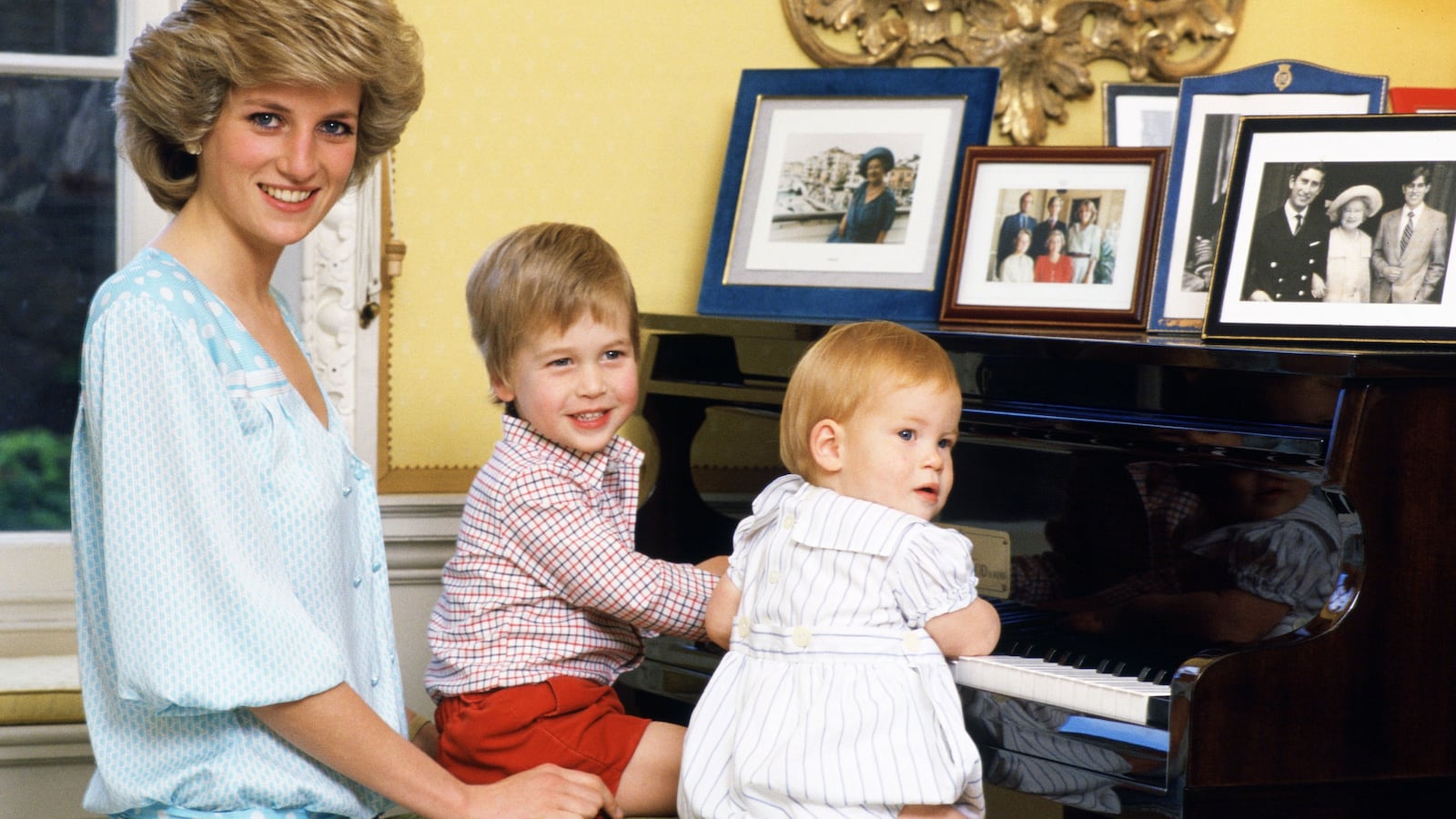 Princess Diana is pictured with her young sons Prince William and Prince Harry at the piano in Kensington Palace on October 4, 1985.