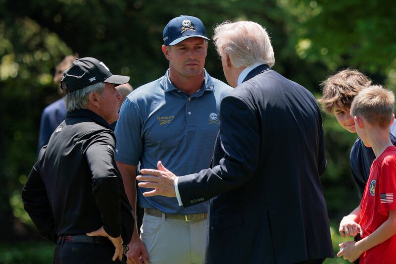 U.S. President Donald Trump speaks with professional golfer Bryson DeChambeau and retired professional golfer Gary Player during an event held for National Youth Sports and Fitness Month, on the South Lawn of the White House in Washington, D.C., U.S., May 5, 2026. REUTERS/Evan Vucci