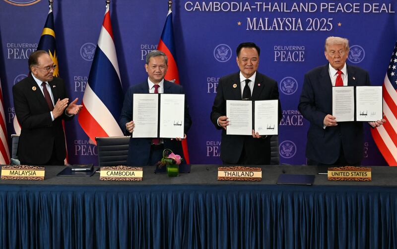 (From L t R) Malaysia's Prime Minister Anwar Ibrahim applauds as Cambodia's Prime Minister Hun Manet, Thailand's Prime Minister Anutin Charnvirakul and US President Donald Trump hold up documents during the ceremonial signing of a ceasefire agreement between Thailand and Cambodia on the sidelines of the 47th Association of Southeast Asian Nations (ASEAN) Summit in Kuala Lumpur on October 26, 2025. (Photo by MOHD RASFAN / POOL / AFP) (Photo by MOHD RASFAN/POOL/AFP via Getty Images)