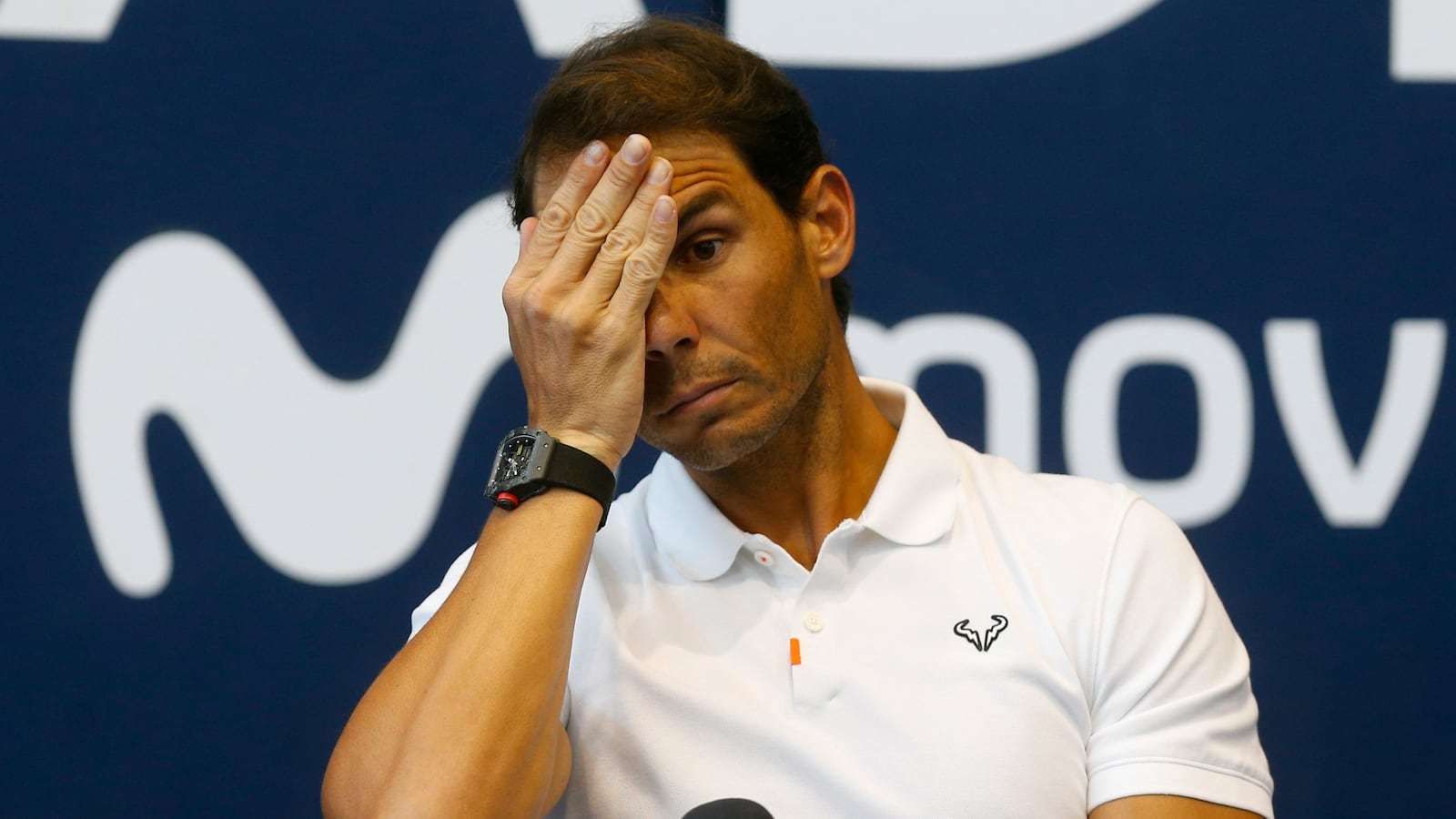 Rafael Nadal puts a hand over his face during a press conference.