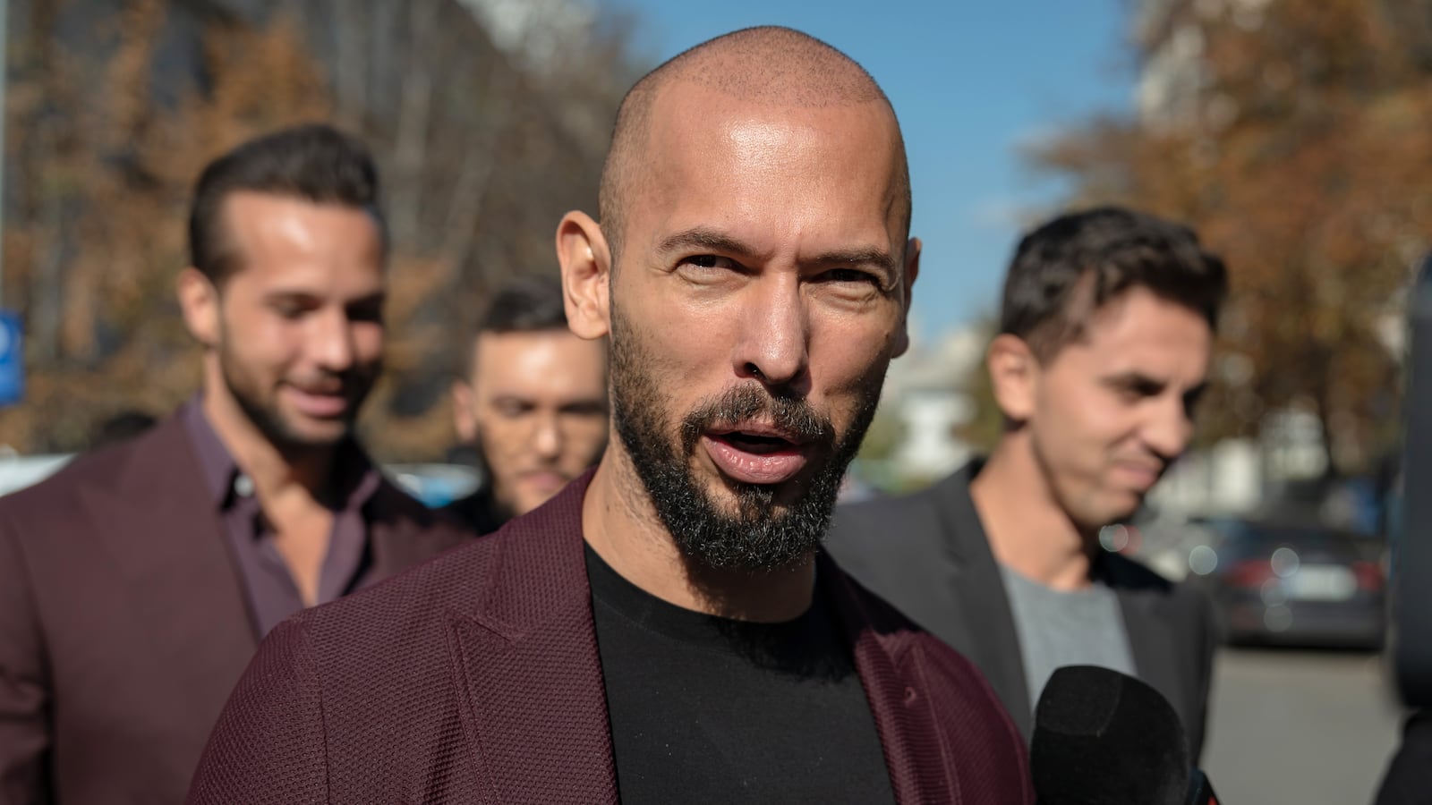 Andrew Tate addresses reporters outside a court in Bucharest, Romania, in October.
