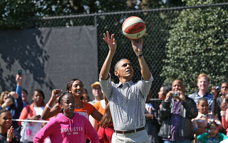 U.S. President Barack Obama plays basketball with children during the annual Easter Egg Roll on the White House tennis court April 1, 2013 in Washington, DC.