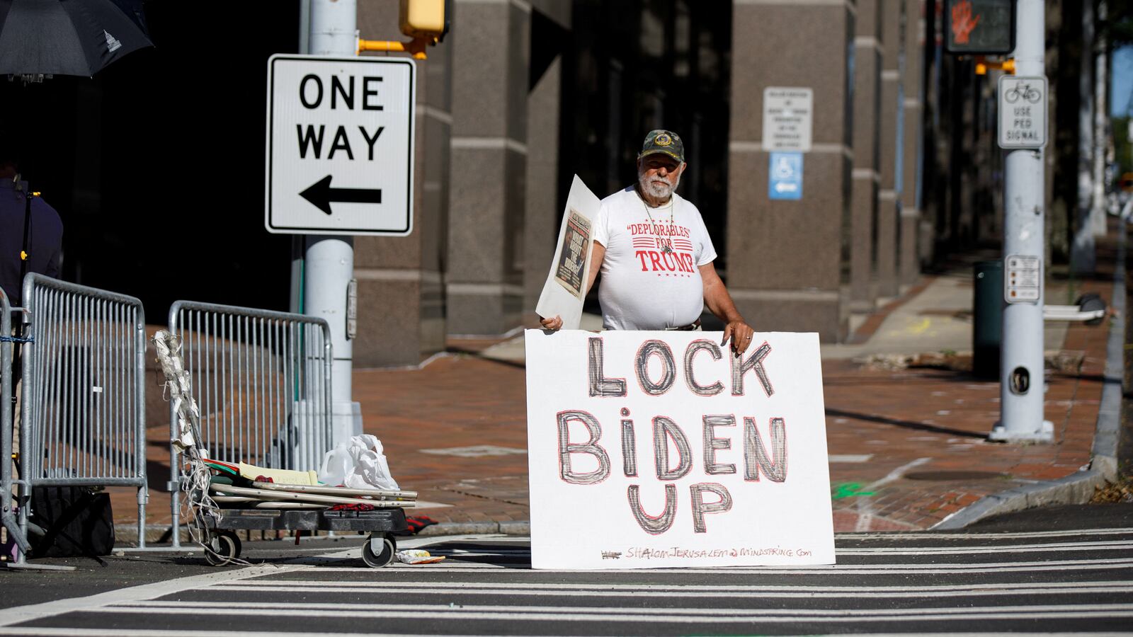 A demonstrator supporting former U.S. President Donald Trump stands outside of the Lewis R. Slaton Courthouse, after a Grand Jury brought back indictments against Trump and 18 of his allies in their attempt to overturn the state's 2020 election results.