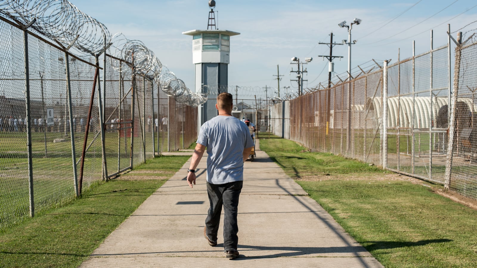 ANGOLA PRISON, LOUISIANA - OCTOBER 14, 2013: A prisoner walks thru a fenced section toward a guard tower at Angola Prison
The Louisiana State Penitentiary, also known as Angola, and nicknamed the "Alcatraz of the South" and "The Farm" is a maximum-security prison farm in Louisiana operated by the Louisiana Department of Public Safety & Corrections. It is named Angola after the former plantation that occupied this territory, which was named for the African country that was the origin of many enslaved Africans brought to Louisiana in slavery times.
This is the largest maximum-security prison in the United States[with 6,300 prisoners and 1,800 staff, including corrections officers, janitors, maintenance, and wardens. It is located on an 18,000-acre (7,300 ha) property that was previously known as the Angola Plantations and bordered on three sides by the Mississippi River.
(Photo by Giles Clarke/Getty Images)