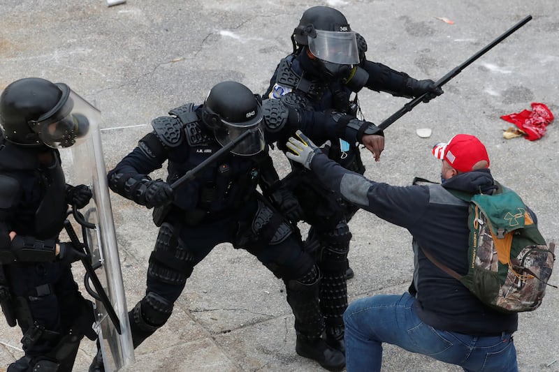Police confront a supporter outside the U.S. Capitol during the Jan. 6 riots.