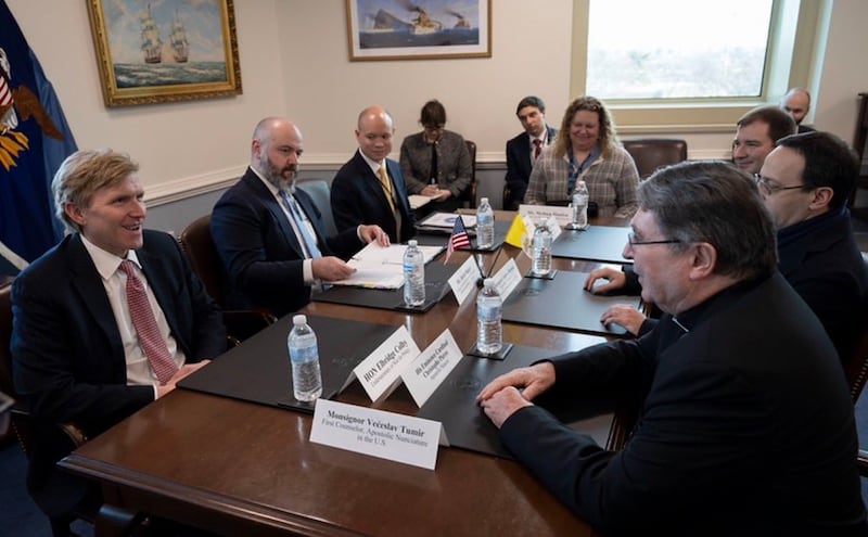 A group of men around a table.