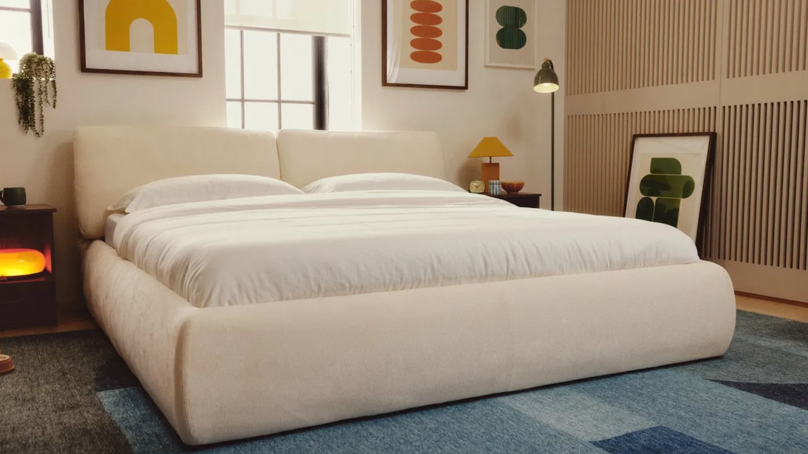 Cozey Ara Bed System styled in a modern bedroom with upholstered bed frame, neutral fabric finish, white bedding, and minimalist decor