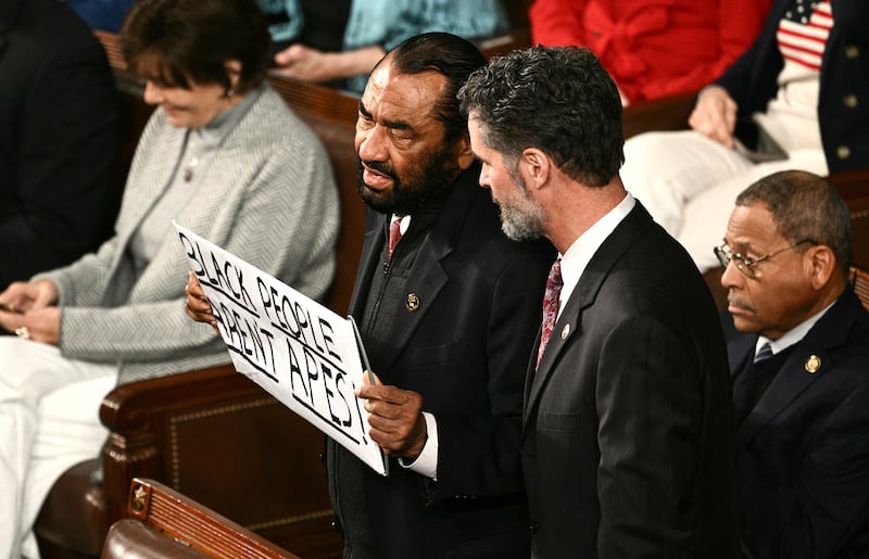 Representative Al Green, a democrat from Texas, holds a sign reading "Black People Aren't Apes" as he is escorted out during US President Donald Trump's State of the Union address in the House Chamber of the US Capitol in Washington, DC, on Feb. 24, 2026.