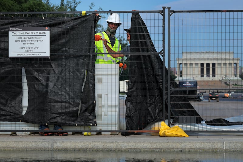 WASHINGTON, DC - MAY 28: Workers attach black fabric to the fence around the Lincoln Memorial Reflecting Pool as part of a painting project on the National Mall on May 28, 2026 in Washington, DC. Painting the landmark is part of President Donald Trump's effort to repair Washington landmarks in preparation for the country’s 250th birthday this summer. (Photo by Chip Somodevilla/Getty Images)