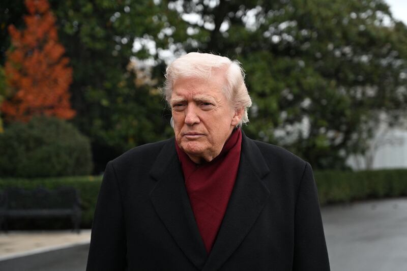 US President Donald Trump listens while taking questions from the press before boarding Marine One on the South Lawn of the White House in Washington, DC, on November 22, 2025 as he heads to visit The Courses at Joint Base Andrews, Maryland. (Photo by Alex WROBLEWSKI / AFP via Getty Images)