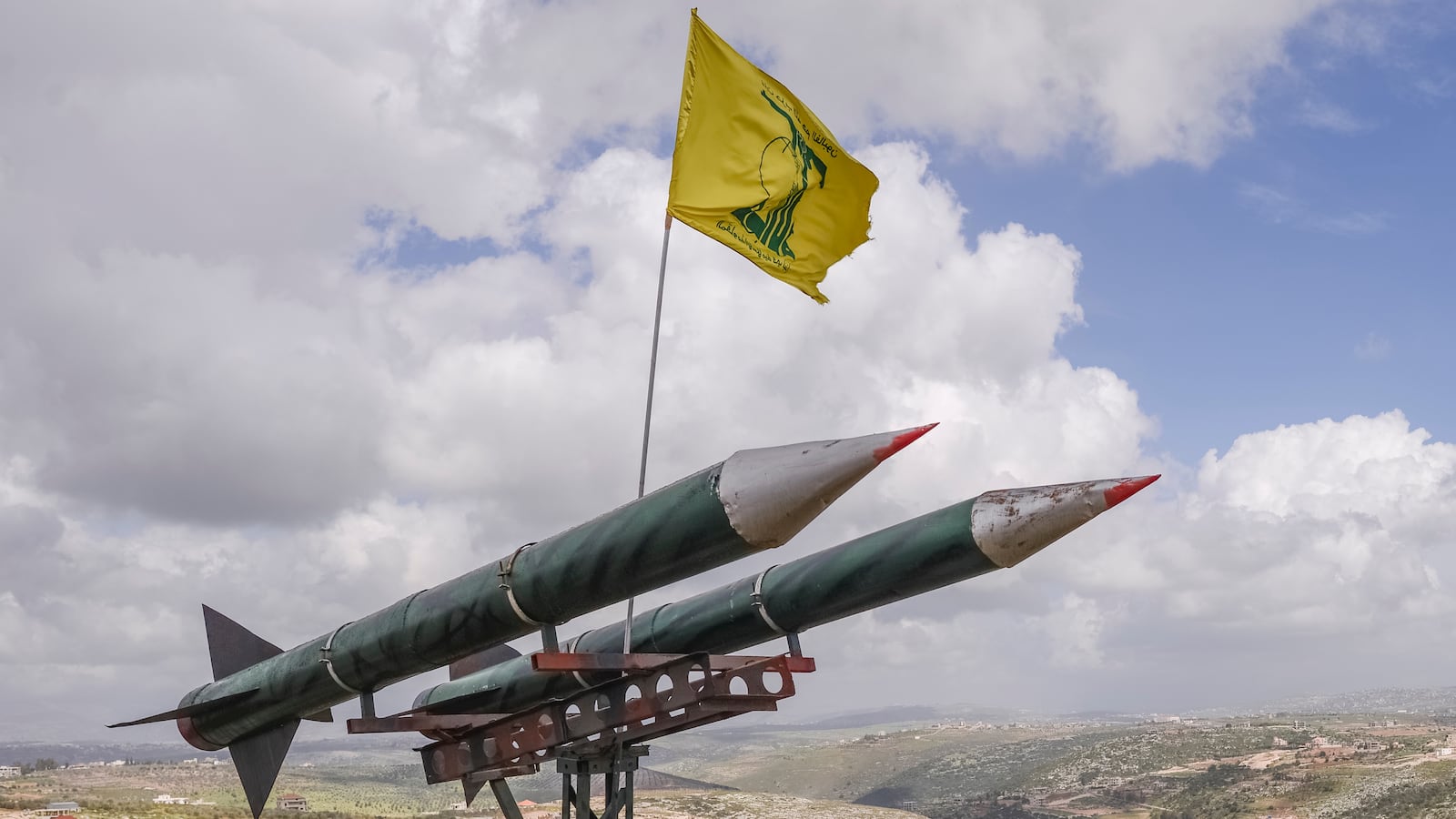 A Hezbollah flag flies over two rockets in Southern Lebanon.
