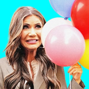 Kristi Noem making an awkward face holding balloons