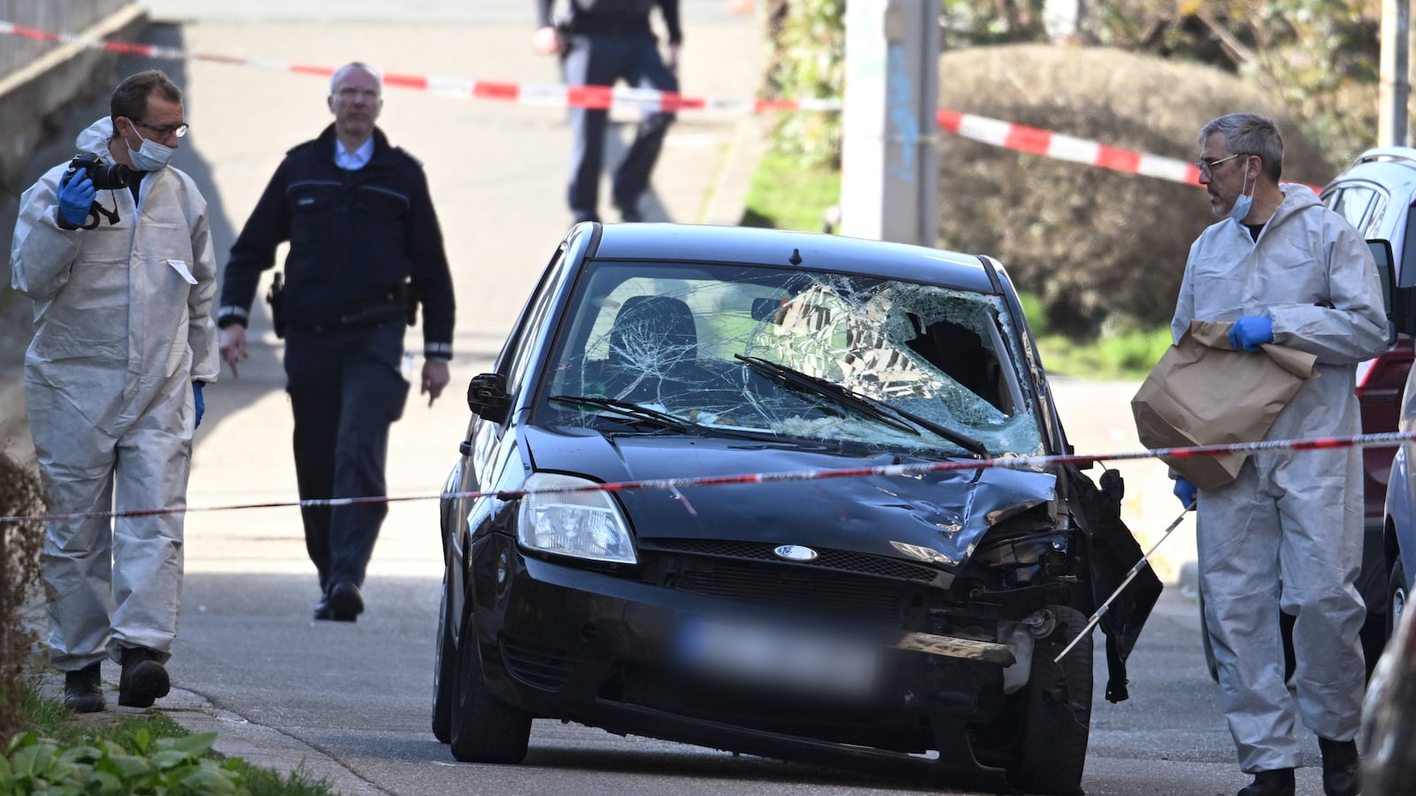 Forensics officers examine a damaged vehicle on an access road to the Rhine bridge in the German city of Mannheim on March 3, 2025.
