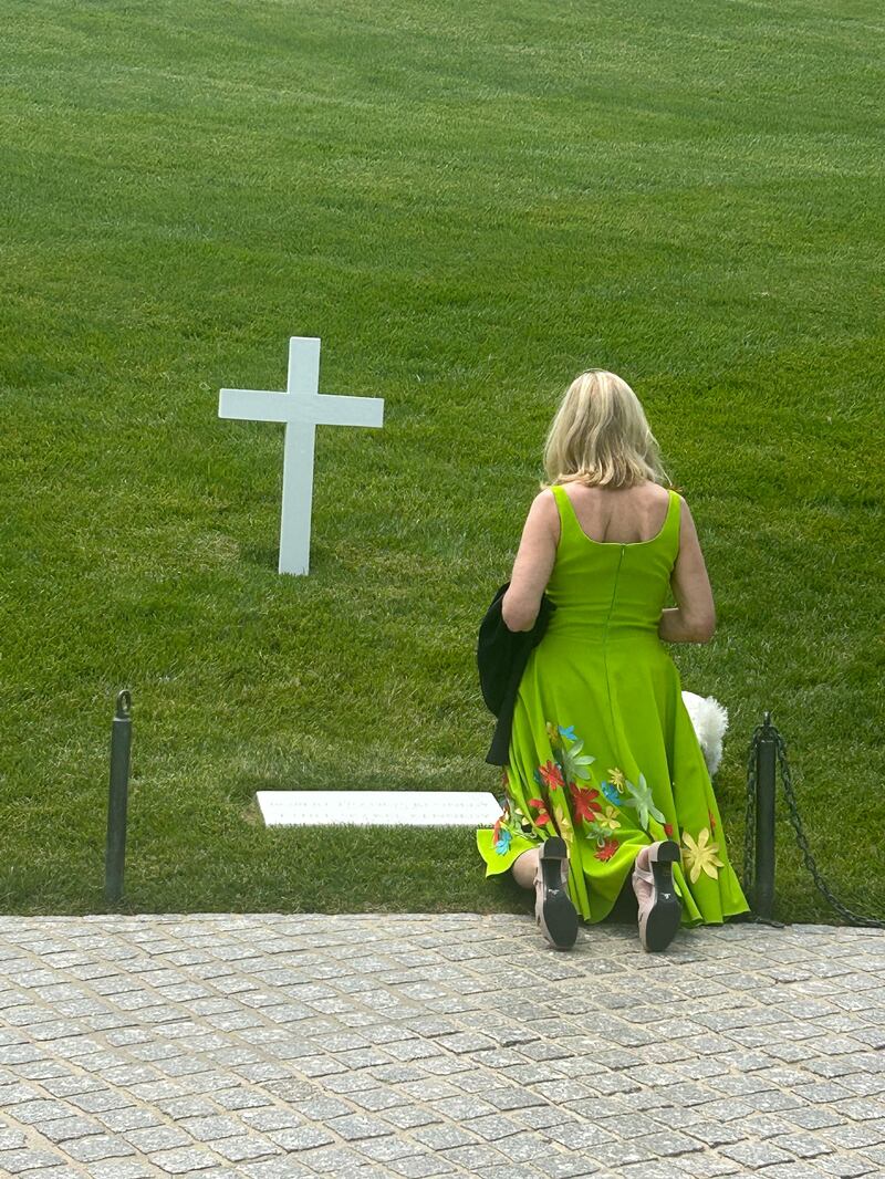 Kerry Kennedy kneels in prayer at her parents' grave at Arlington Cemetery.