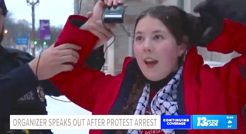 Jessica Plichta looks surprised to be grabbed by police as she wrapped up her TV interview, complaining about Maduro's capture.