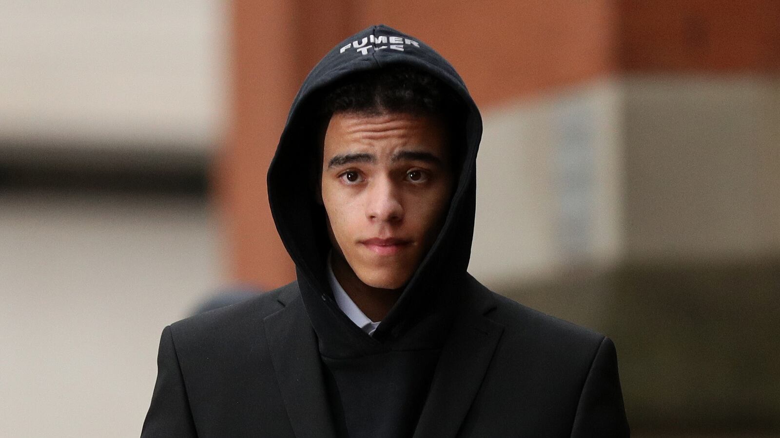 Mason Greenwood walks in a black hoodie.