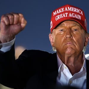 Donald Trump raises his fist as he looks on during the NASCAR Cup Series Coca-Cola 600 at Charlotte Motor Speedway on May 26, 2024 in Concord, North Carolina.