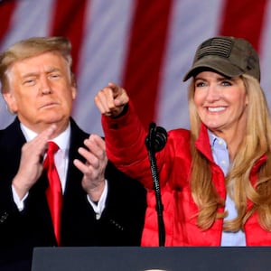 US President Donald Trump claps as Republican incumbent senator Kelly Loeffler speaks during a rally ahead of Senate the runoff in Dalton, Georgia on January 4, 2021. - President Donald Trump, still seeking ways to reverse his election defeat, and President-elect Joe Biden converge on Georgia on Monday for dueling rallies on the eve of runoff votes that will decide control of the US Senate. Trump, a day after the release of a bombshell recording in which he pressures Georgia officials to overturn his November 3 election loss in the southern state, is to hold a rally in the northwest city of Dalton in support of Republican incumbent senators Kelly Loeffler and David Perdue. (Photo by SANDY HUFFAKER / AFP) (Photo by SANDY HUFFAKER/AFP via Getty Images)