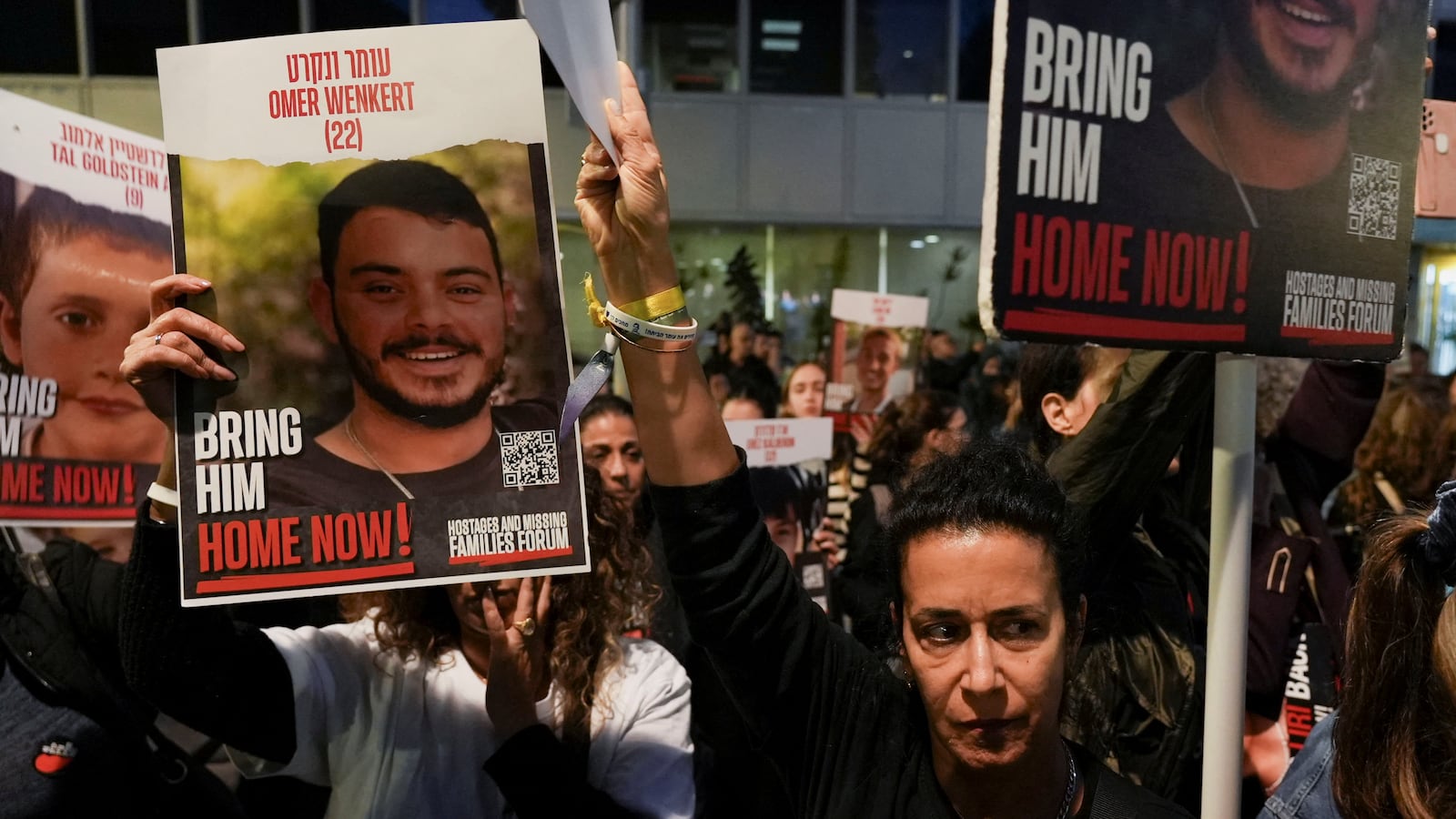 Signs are held displaying the faces and names of Israeli hostages in Gaza.