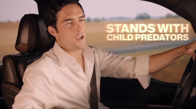 A man with looking from the side while driving his car with the words "stands with child predators"
