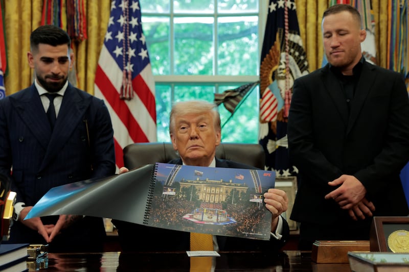 President Donald Trump shows an image of the White House with the Octagon, as he holds an event with UFC fighters Justin Gaethje and Ilia Topuria, in the Oval Office at the White House in Washington, D.C., U.S., May 6, 2026.