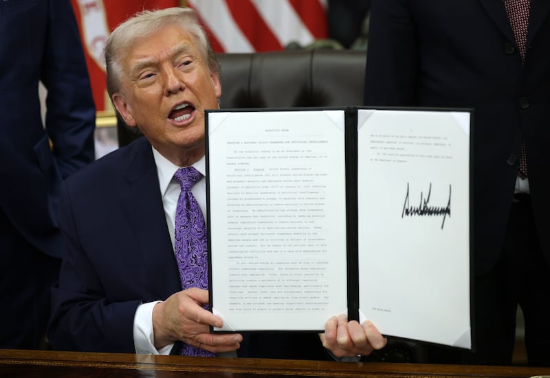 WASHINGTON, DC - DECEMBER 11: U.S. President Donald Trump displays a signed executive order in the Oval Office of the White House on December 11, 2025 in Washington, DC. The executive order curbs states' ability to regulate artificial intelligence, something for which the tech industry has been lobbying.  (Photo by Alex Wong/Getty Images)