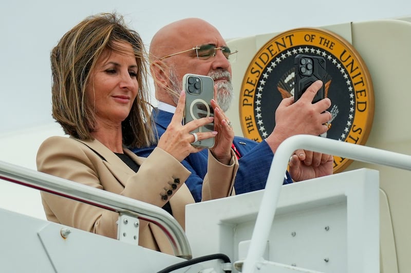 Trump Campaign Finance Director Meredith O’Rourke and American political consultant, Chris LaCivita, take pictures of U.S. President Donald Trump as he arrives on Marine One at Joint Base Andrews, in Maryland U.S., August 1, 2025. REUTERS/Ken Cedeno
