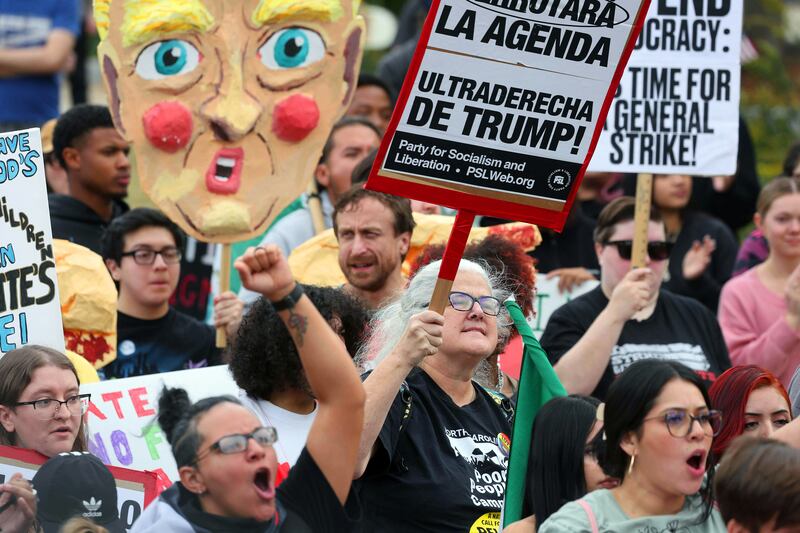 Protesters yell and hold signs Saturday, Nov. 15, 2025, during the No Border Patrol protest in uptown Charlotte