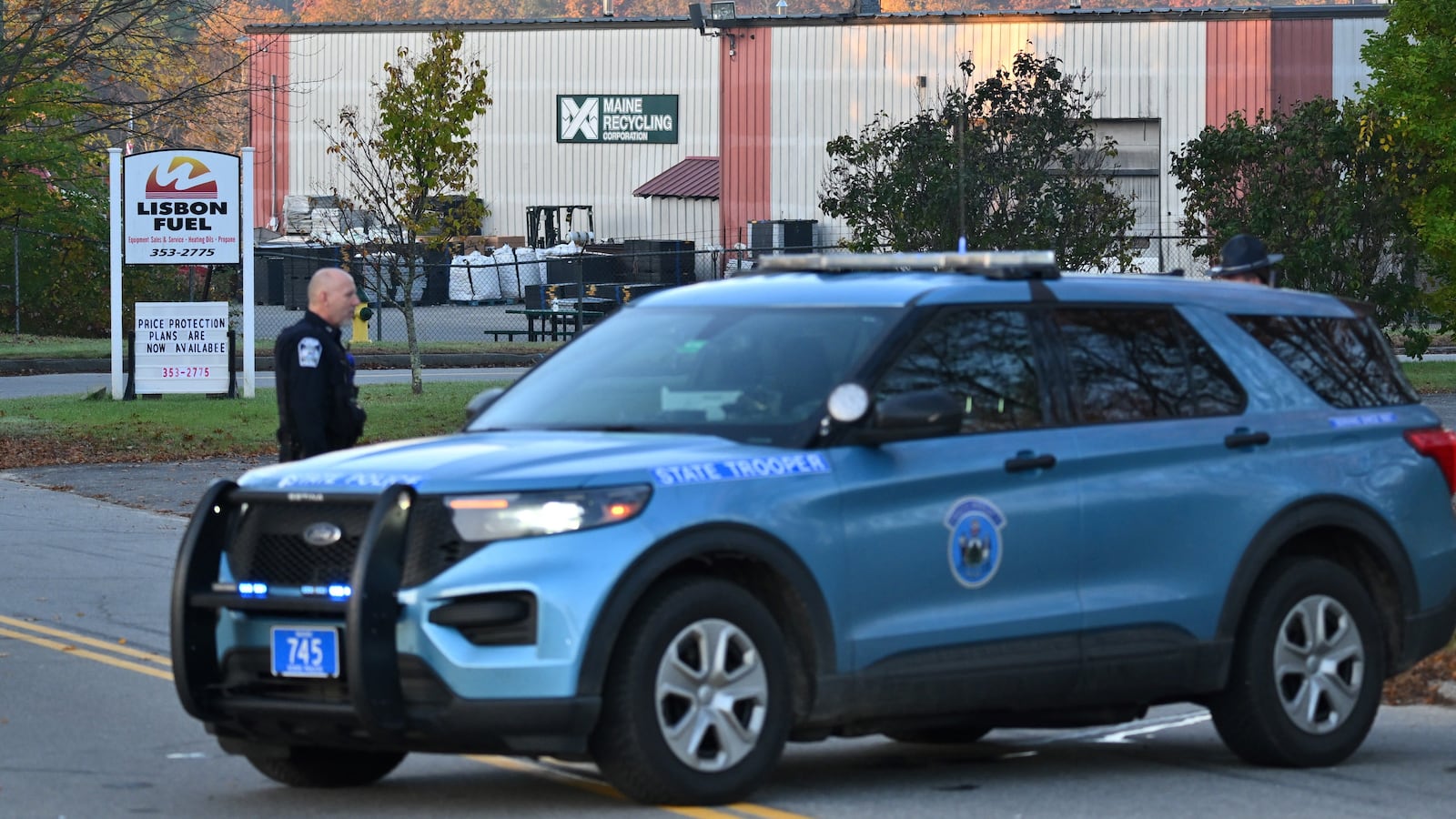 Police stand near the recycling plant where the body of suspected mass shooter Robert Card was found in Lisbon Falls, Maine.